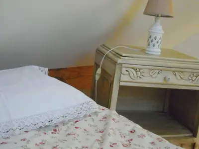 a bed with a table with a lamp on it at Holiday home Brokantie in Pamel