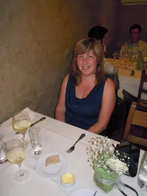 a woman sitting at a table with wine glasses at Holiday home Brokantie in Pamel