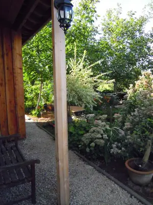 a wooden pole with a light next to a garden at Holiday home Brokantie in Pamel