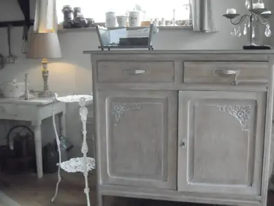 a wooden dresser with a mirror and a table at Holiday home Brokantie in Pamel