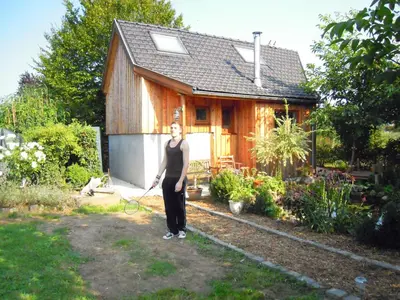 a woman is standing in front of a house at Holiday home Brokantie in Pamel