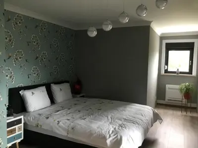 a bedroom with a bed with a green wall at Gesloten in Geraardsbergen