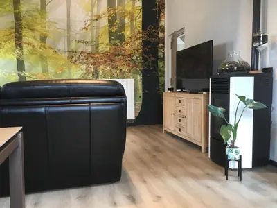 a living room with a black leather couch and a tv at Gesloten in Geraardsbergen