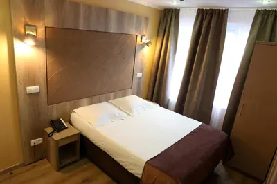 a bedroom with a bed with a large headboard at Hotel Phenix in Brussels