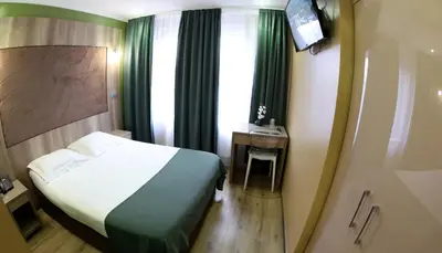a hotel room with a bed and a television at Hotel Phenix in Brussels
