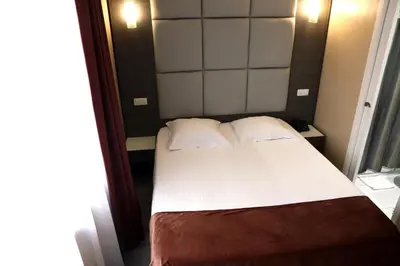 a bedroom with a bed with white sheets and pillows at Hotel Phenix in Brussels