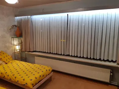 a bedroom with a bed and a large window with curtains at CASA DI MARCO in Antwerp