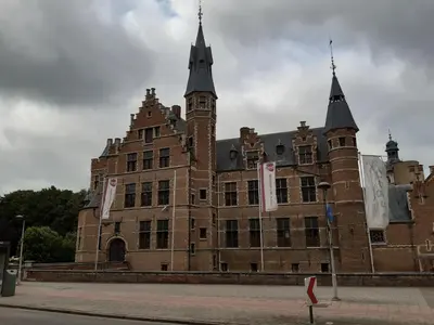 a large brick building with two towers on a street at CASA DI MARCO in Antwerp