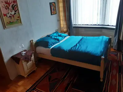 a bedroom with a bed with blue sheets and a window at CASA DI MARCO in Antwerp