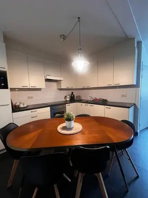 a kitchen with a wooden table and black chairs at Anna Place in Ghent