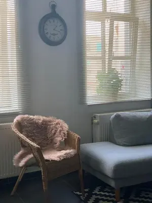 a room with a chair and a clock on the wall at Anna Place in Ghent