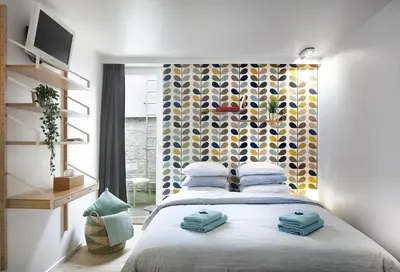 a bedroom with a large bed with blue pillows at Alphabed & Bike in Ghent