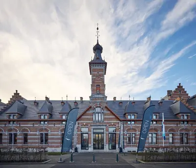 a large brick building with a clock tower at Van der Valk Hotel Mechelen in Mechelen