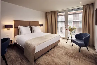 a hotel room with a bed and a chair at Van der Valk Hotel Mechelen in Mechelen