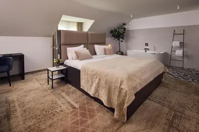 a bedroom with a large bed and a sink at Van der Valk Hotel Mechelen in Mechelen
