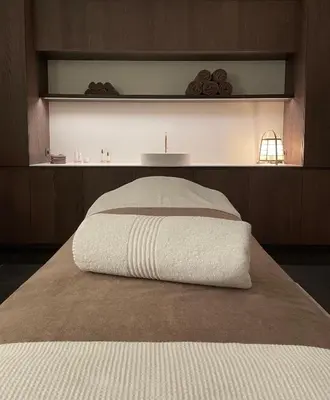 a bed with a white blanket on top of it at Relax Select in Munte