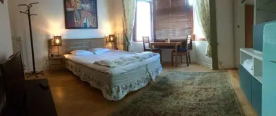 a bedroom with a bed and a table in it at Appart-hôtel Maison de la Lune - petite Auberge d'Etterbeek in Brussels