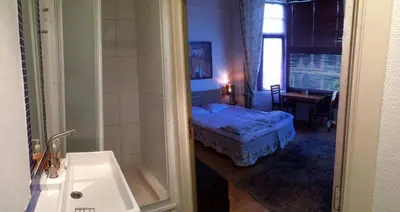 a bathroom with a bedroom with a bed and a sink at Appart-hôtel Maison de la Lune - petite Auberge d'Etterbeek in Brussels