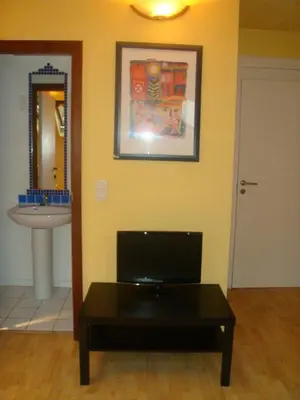 a living room with a table and a sink at Appart-hôtel Maison de la Lune - petite Auberge d'Etterbeek in Brussels