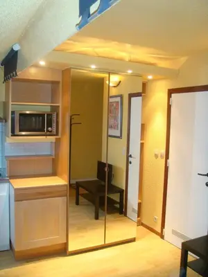 a room with a kitchen with a microwave and a table at Appart-hôtel Maison de la Lune - petite Auberge d'Etterbeek in Brussels