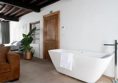 a white bath tub in a living room with a couch at The Greenhouse in Antwerp