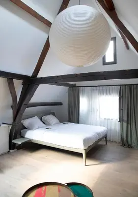 a bedroom with a white bed and a large light fixture at The Greenhouse in Antwerp