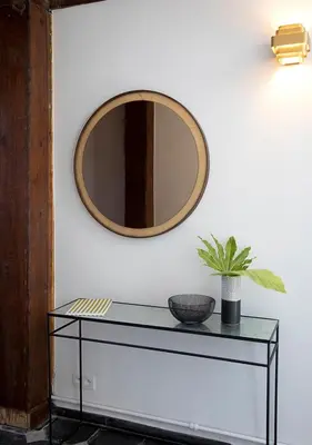 a mirror on a wall with a glass table at The Greenhouse in Antwerp