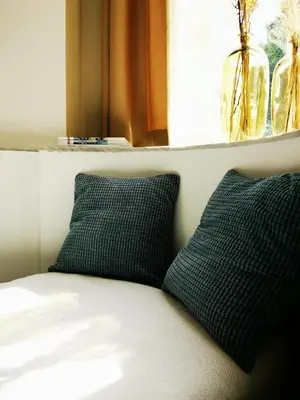 two pillows sitting on a bed next to a window at SHWAY - The Red With Pearls in Antwerp