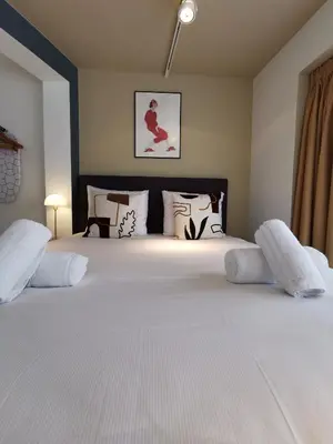 a bedroom with a large bed with white sheets and pillows at SHWAY - The Red With Pearls in Antwerp