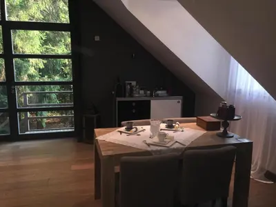 a dining room with a table and a large window at B&B Des Heures Claires in Lasne