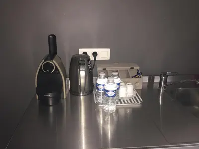 a counter top with bottles of water and a coffee maker at B&B Des Heures Claires in Lasne