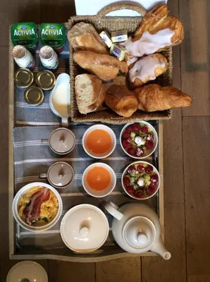 a tray of food with bread and pastries on it at B&B Des Heures Claires in Lasne