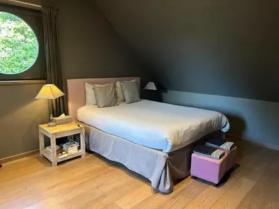 a bedroom with a large bed with a window at B&B Des Heures Claires in Lasne