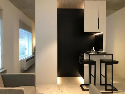 a living room with a table and a black wall at studio medieval city center at river de Leie in Ghent