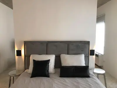 a bedroom with a large bed with two black pillows at studio medieval city center at river de Leie in Ghent