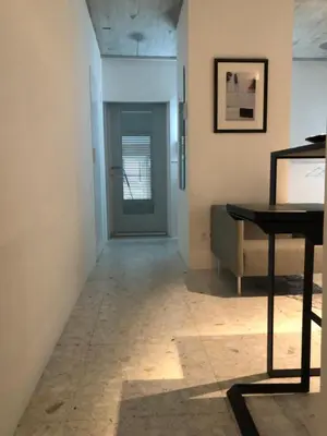 a hallway with a door and a table and a piano at studio medieval city center at river de Leie in Ghent