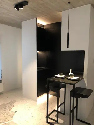 a dining room with a table and a black wall at studio medieval city center at river de Leie in Ghent