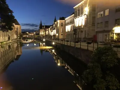 a river in a city at night with buildings at studio medieval city center at river de Leie in Ghent