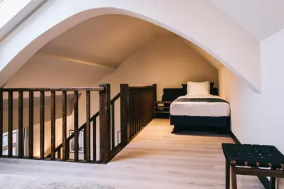 an attic room with a bed and a staircase at Getaway Gent in Ghent
