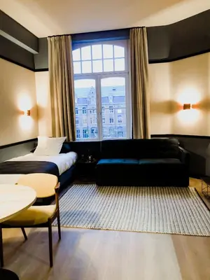 a hotel room with a couch and a window at Getaway Gent in Ghent