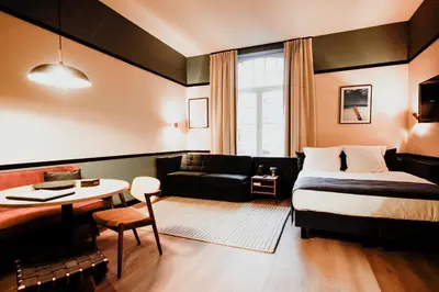 a hotel room with a bed and a table and a couch at Getaway Gent in Ghent