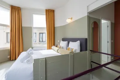 a bedroom with a large bed and a window at SHWAY - The Black Pants in Antwerp
