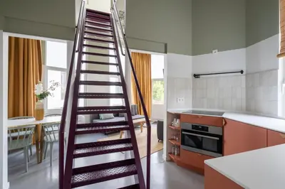 a kitchen with a wooden spiral staircase in a kitchen at SHWAY - The Black Pants in Antwerp