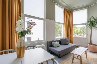 a living room with a vase of flowers on a table at SHWAY - The Black Pants in Antwerp