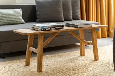 a wooden coffee table with books on it in front of a couch at SHWAY - The Black Pants in Antwerp