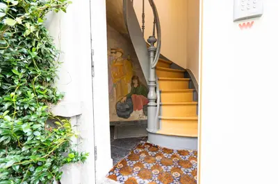 a stairway with a painting of a woman on the wall at SHWAY - The Black Pants in Antwerp