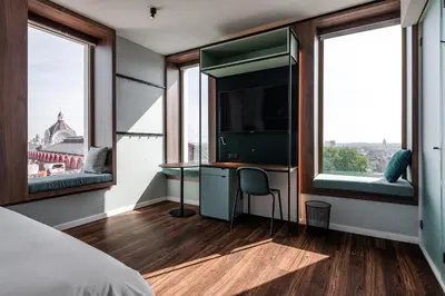 a bedroom with a desk and a tv and windows at A-STAY Antwerp in Antwerp