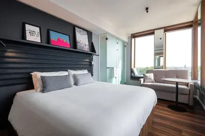a bedroom with a large white bed and a chair at A-STAY Antwerp in Antwerp