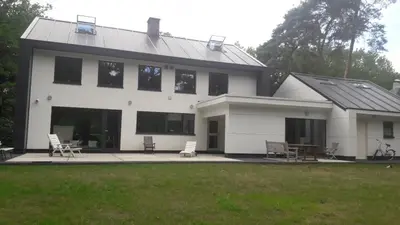 a white house with two chairs and a table at GOLF APARTMENT in Schilde