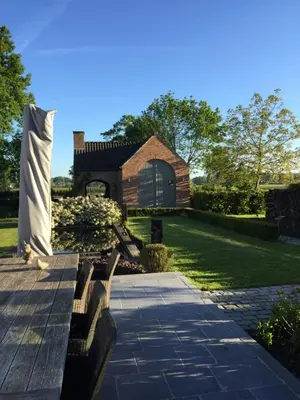 a garden with a bench and a building at Bed and Breakfast Bobilou in Kalmthout
